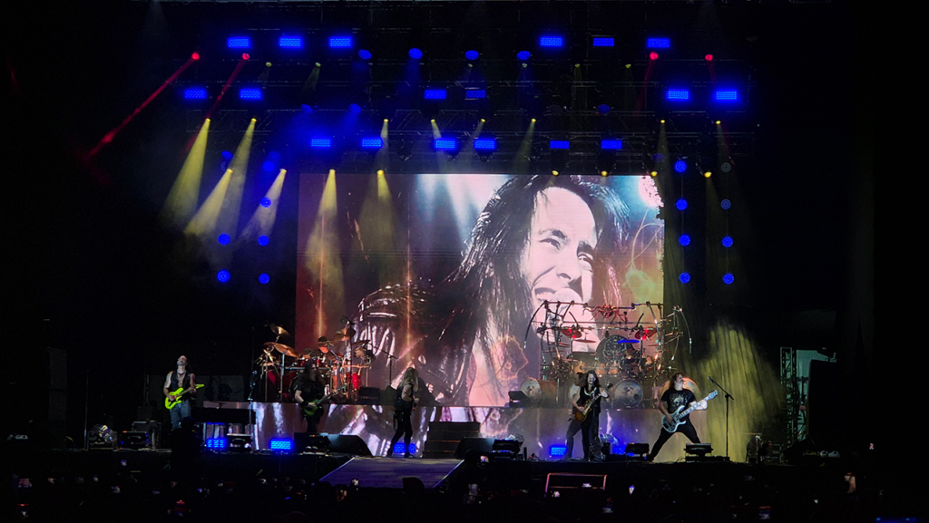 Foto do Bangers Open Air com o Angra no palco e foto do Andre Mattos no telão