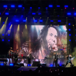 Foto do Bangers Open Air com o Angra no palco e foto do Andre Mattos no telão